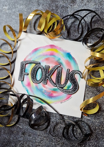Tinas Jahresmotto "Fokus" als Lettering für die Pinnwand, dekoriert mit Luftschlangen