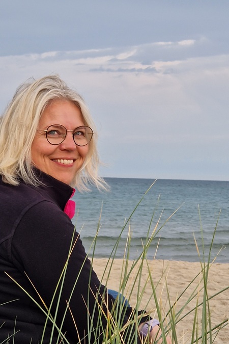 Tina sitzt in den Dünen am Strand
