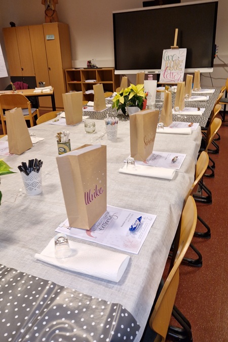 Ein aufwändig geschmückter Tisch mit Materialen für einen anstehenden Handlettering-Workshop