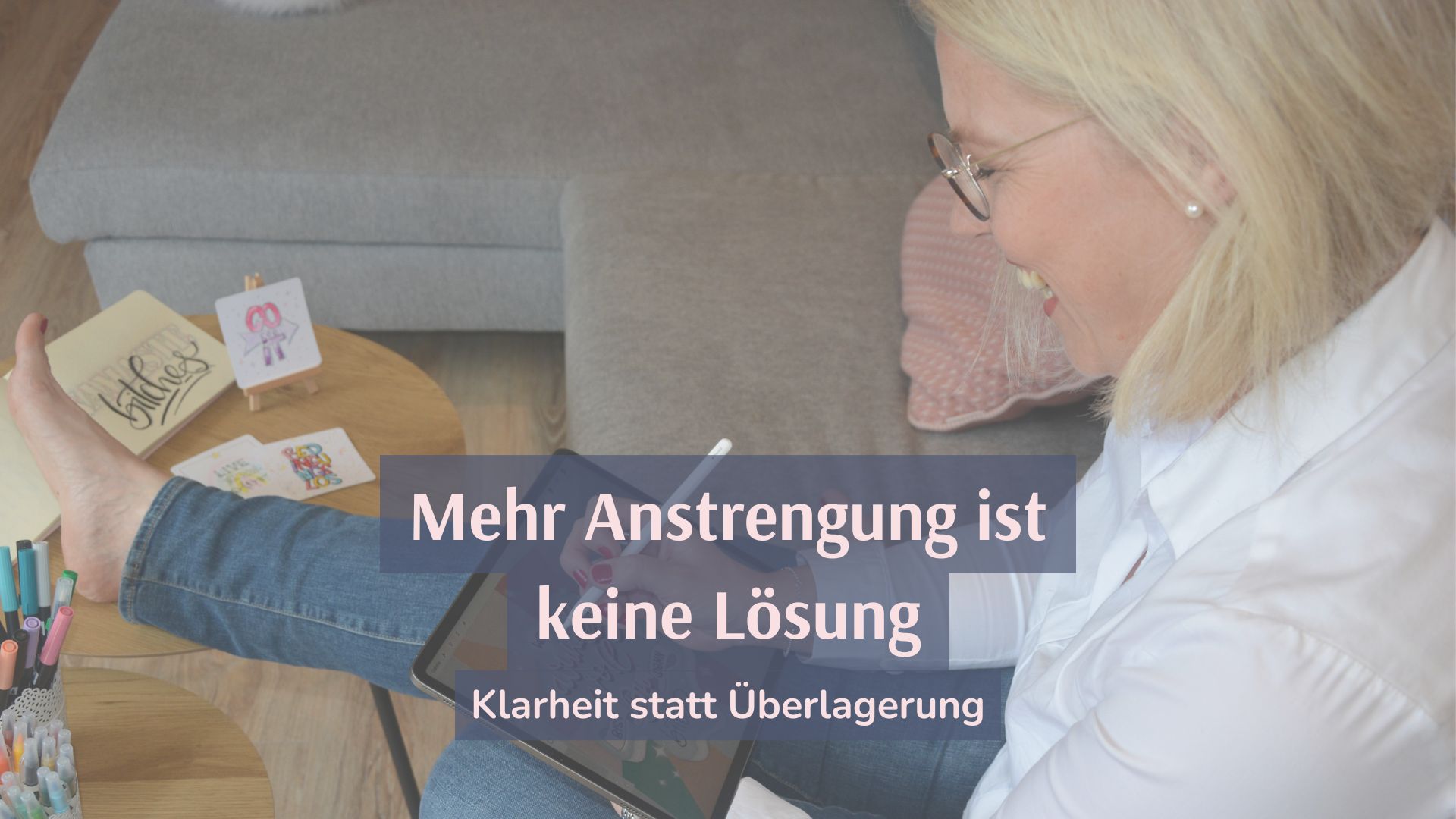 Tina sitzt mit ihrem IPad auf dem Sofa, ein Fuß auf dme Tisch, an der linken Seite bunte Stifte